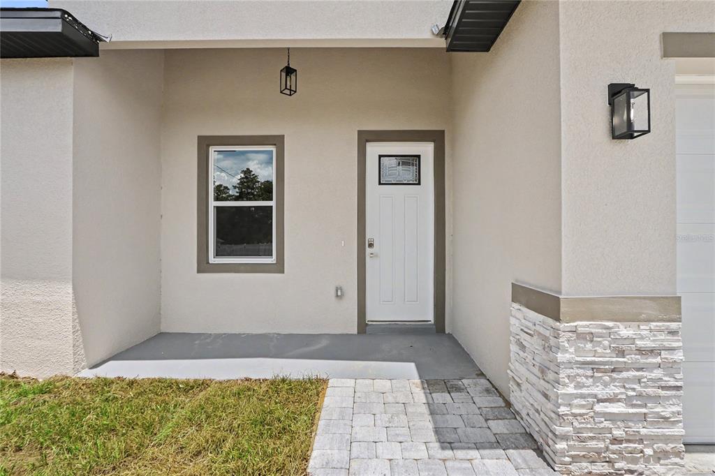 A front entryway features a white door, a single window, and stone veneer siding — 4814 SW 166TH LOOP, OCALA, FL