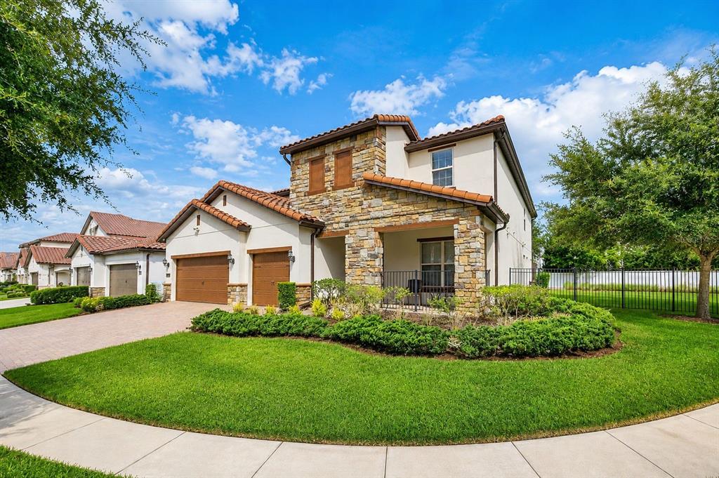 A two-story house with a stone facade, tile roof, and a two-car garage — 10902 CITRON OAKS DRIVE, ORLANDO, FL