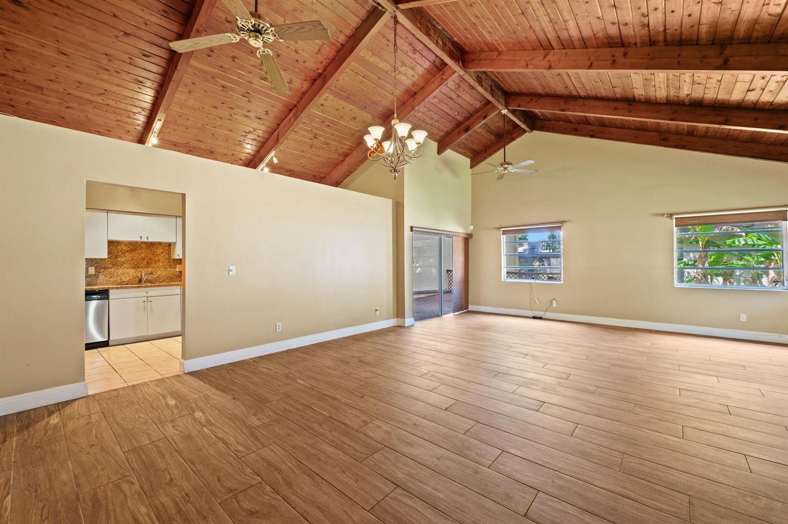 A spacious living room features vaulted wood-paneled ceilings, light-colored walls, and wood-look tile flooring — 2229 Nova Village Drive, Davie FL 33317, DAVIE, FL