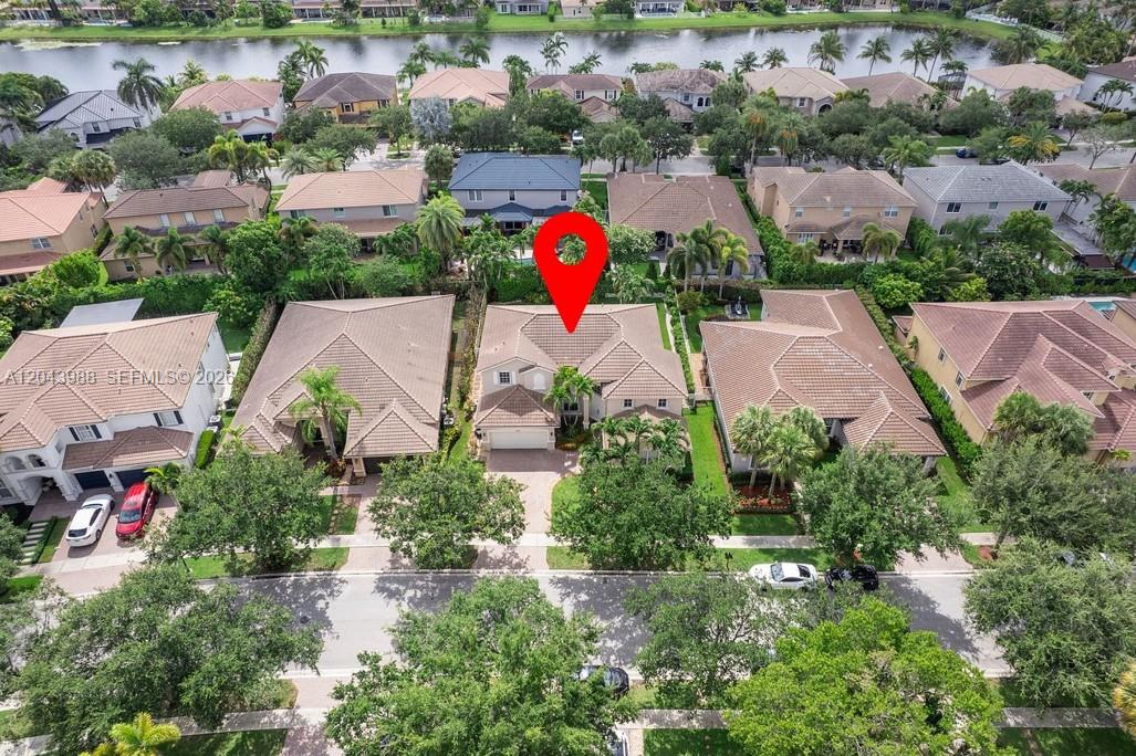 An aerial view shows a residential house with a tiled roof and a red location pin — 3904 W Gardenia Ave, Weston FL 33332, WESTON, FL
