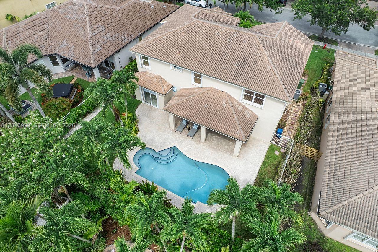 An aerial view shows a two-story house with a tiled roof, pool, and patio — 3904 W Gardenia Ave, Weston FL 33332, WESTON, FL