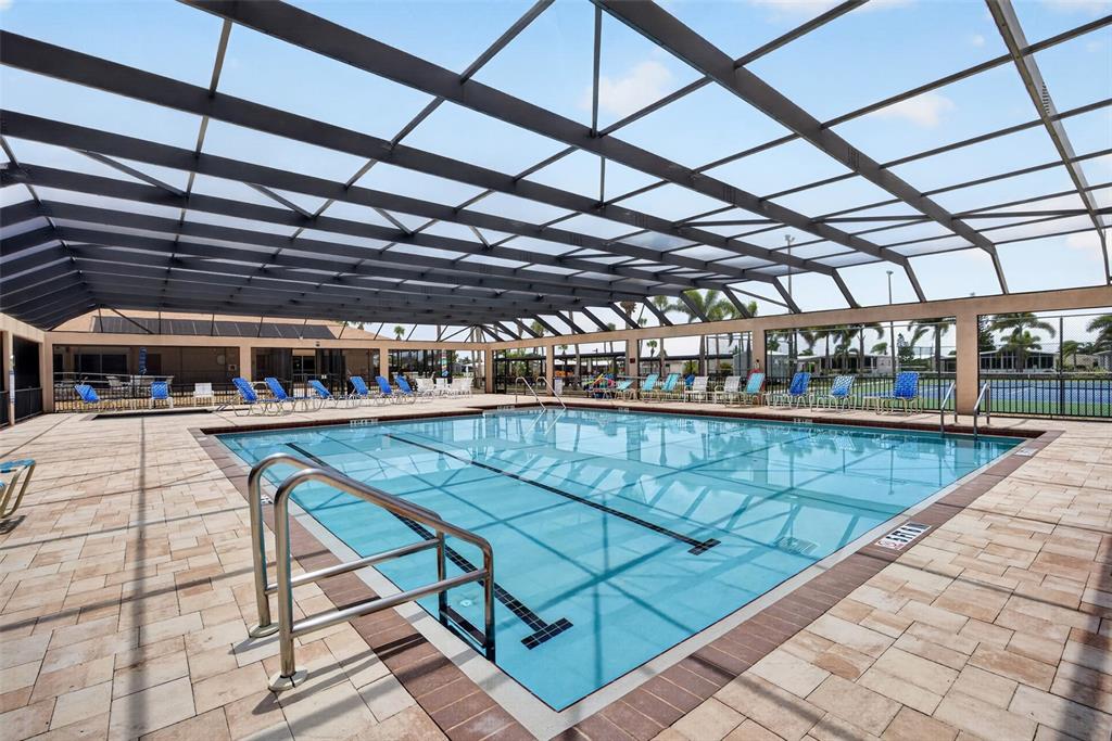 A large rectangular swimming pool is enclosed by a screened lanai with lounge chairs — 15550 BURNT STORE ROAD UNIT 237, PUNTA GORDA, FL