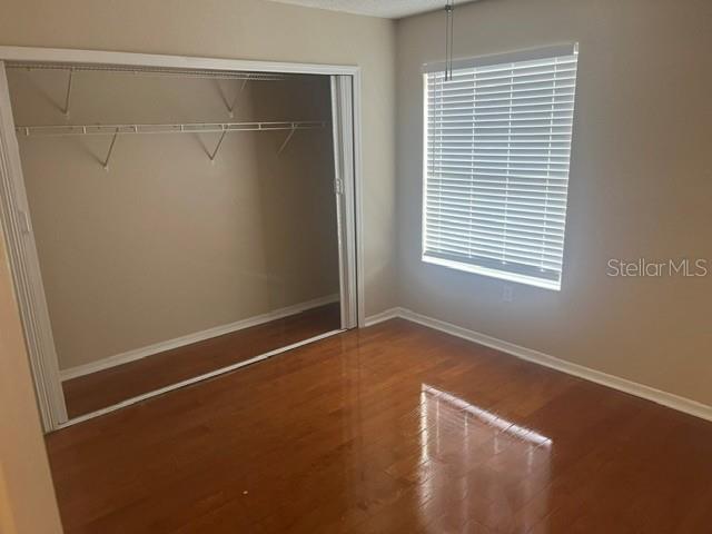 An empty bedroom features hardwood floors, a sliding door closet, and a window with blinds — 685 YOUNGSTOWN PARKWAY UNIT 297, ALTAMONTE SPRINGS, FL