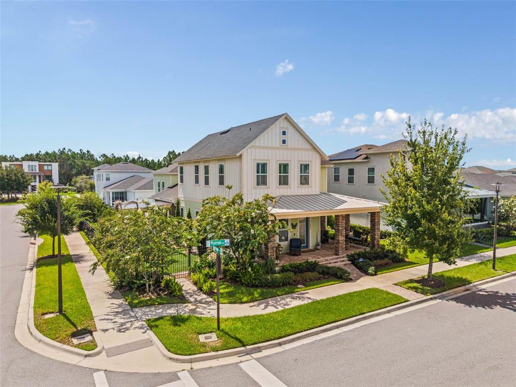 A two-story house with a front porch sits on a corner lot with landscaping — 13901 MYERSON AVENUE, ORLANDO, FL