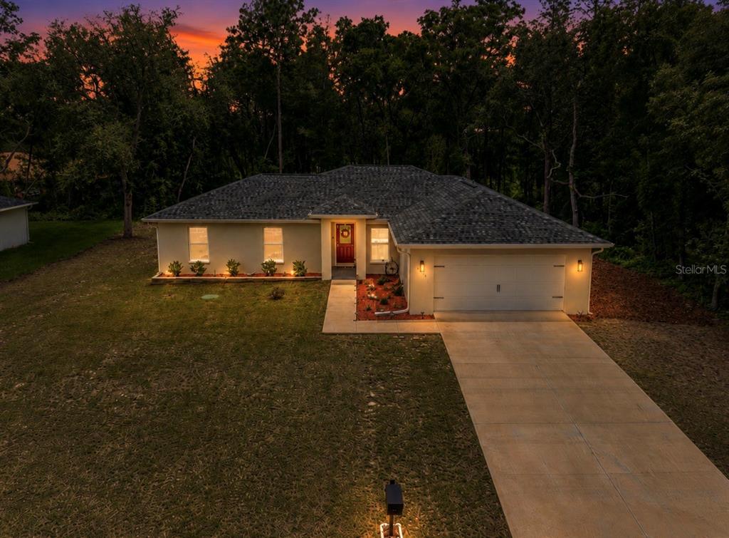 An aerial view of a single-story house with a driveway and a sunset sky background — 10065 N LANGDON ROAD, CITRUS SPRINGS, FL