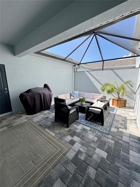 A paved patio features a screened enclosure, outdoor furniture, and a covered grill — 1908 SWIVEL LANE, SARASOTA, FL