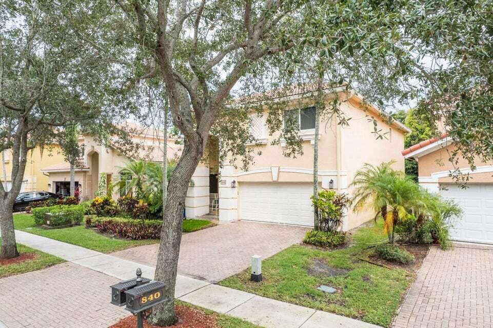 A two-story tan house with a white garage and a brick driveway — 846 Gazetta Way, West Palm Beach FL 33413, WEST PALM BEACH, FL
