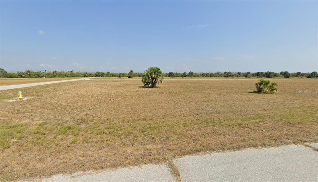 A flat, grassy vacant lot features a few small palm trees and a fire hydrant — 12440 TOADFISH COURT, PLACIDA, FL