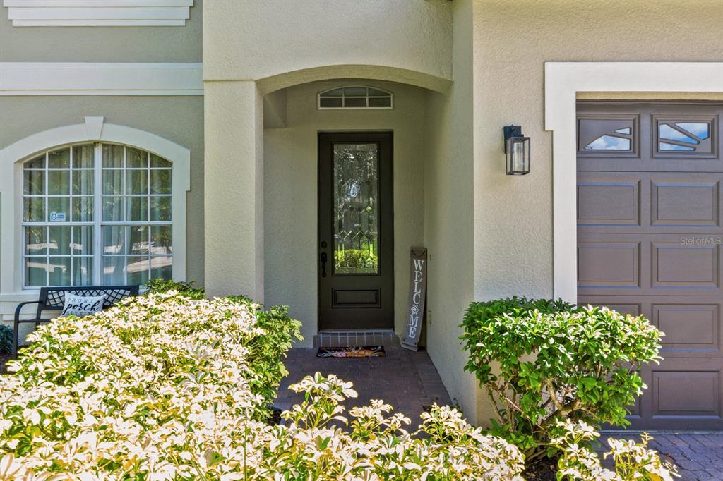 The exterior of a home features a front entrance with a dark door and a garage — 1705 BRIDGETS COURT, KISSIMMEE, FL