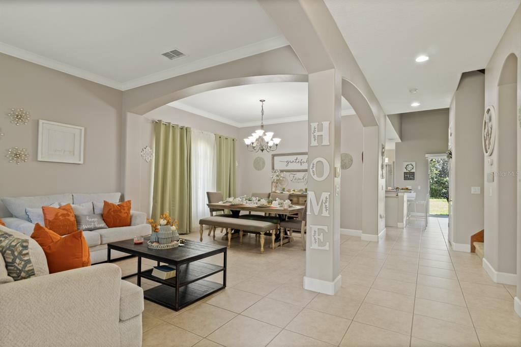A living room and dining area feature neutral walls, tile floors, and an arched entryway — 1705 BRIDGETS COURT, KISSIMMEE, FL