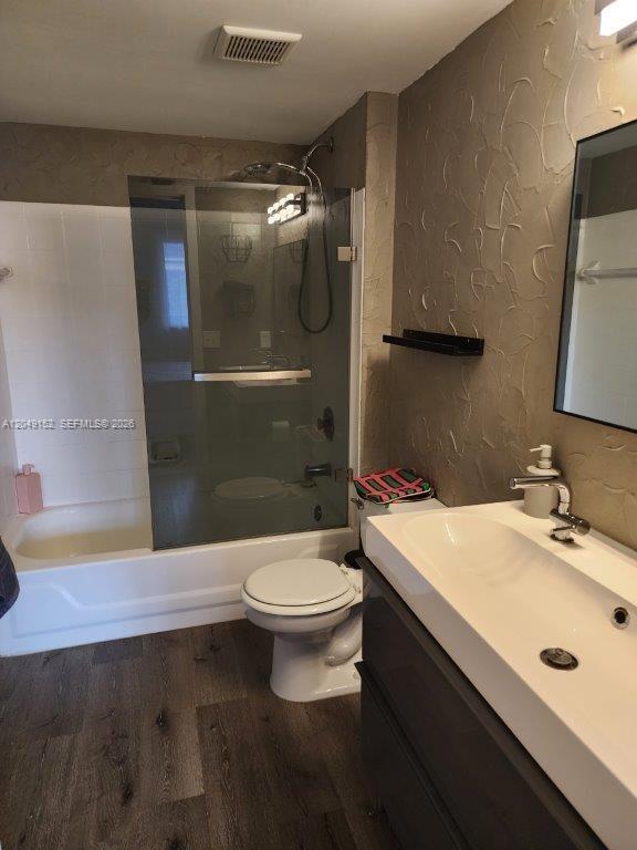 A bathroom features a white vanity, a toilet, and a shower-tub combination with glass doors — 460 S PARK # 209, Hollywood FL 33021, HOLLYWOOD, FL