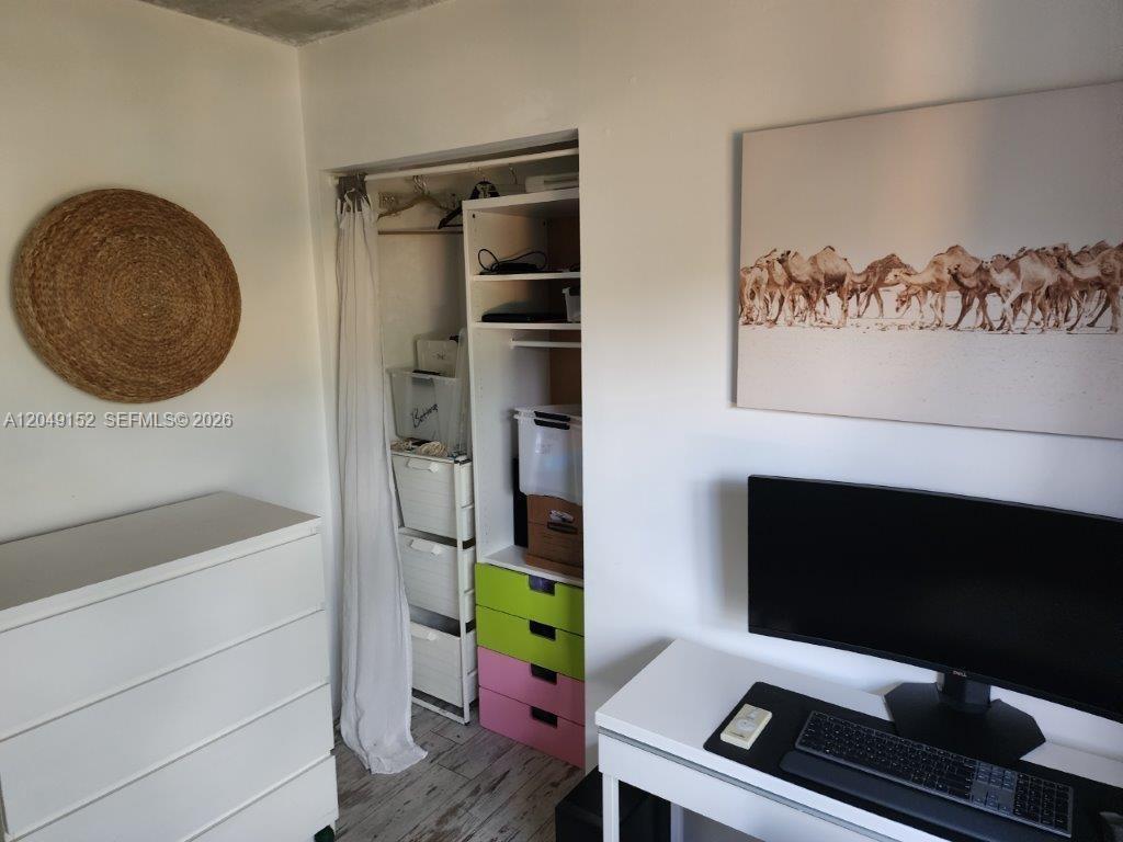 A room features a white desk, a dresser, a closet with colorful drawers, and wall art — 460 S PARK # 209, Hollywood FL 33021, HOLLYWOOD, FL