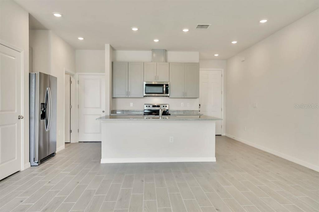 A kitchen features light gray cabinets, stainless steel appliances, and a central island — 1758 WOODLEAF HAMMOCK COURT, BRADENTON, FL