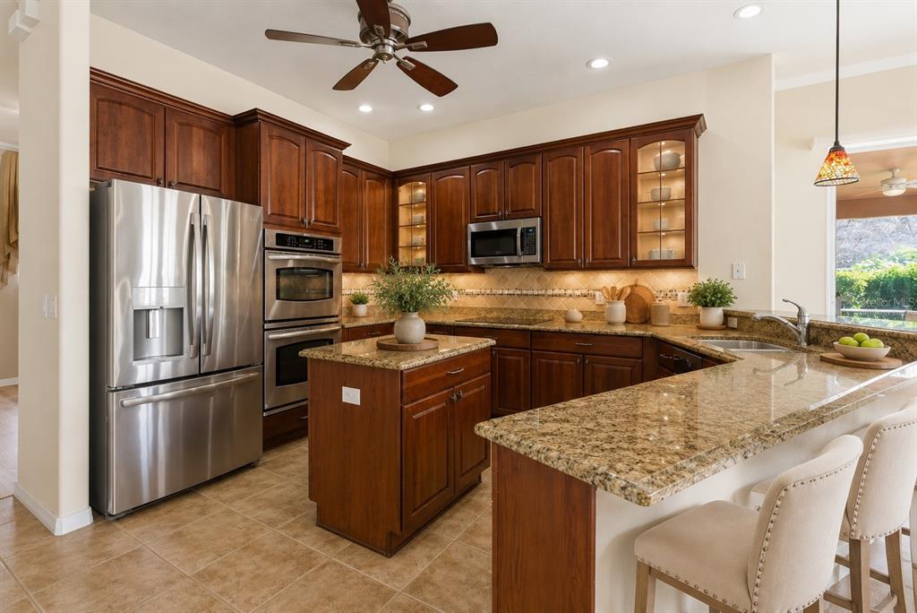 An empty dining room features light-colored walls, wood-look flooring, a chandelier, and an arched window — 915 VISTA VERDE LANE, SUN CITY CENTER, FL