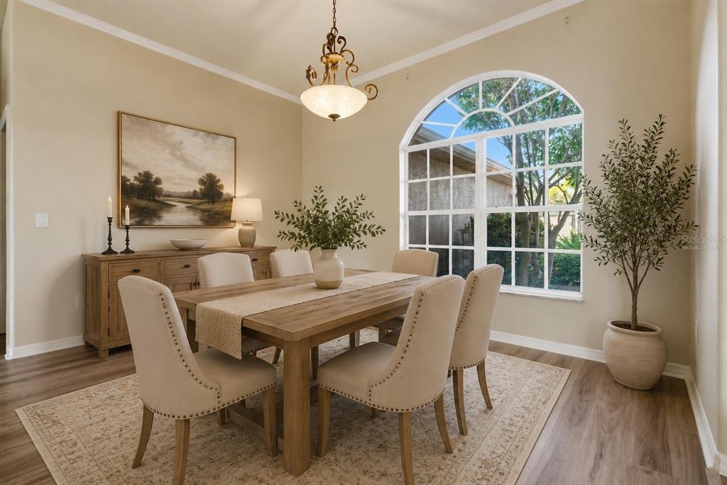 An empty room with wood-look flooring, a decorative wall accent, and sliding doors to a pool — 915 VISTA VERDE LANE, SUN CITY CENTER, FL