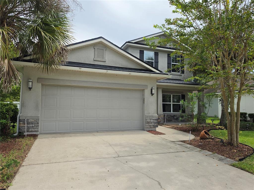 A two-story house with a concrete driveway, a two-car garage, and a front porch — 404 PAISLEY PLACE, ST JOHNS, FL