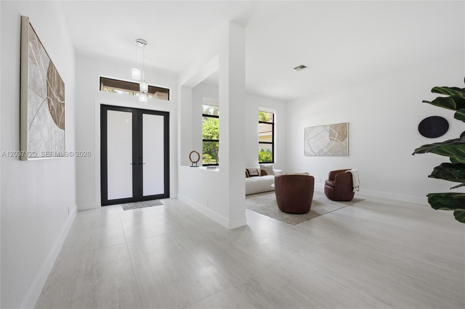 A bright entryway leads to a living area with white walls and light tile floors — 2048 Quail Roost Dr, Weston FL 33327, WESTON, FL