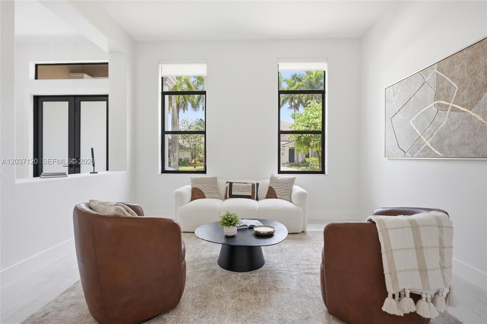 A living room features two brown leather armchairs, a white sofa, and a round table — 2048 Quail Roost Dr, Weston FL 33327, WESTON, FL