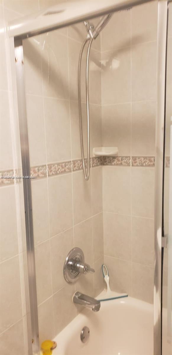 A tiled shower and bathtub combination with a handheld showerhead and glass enclosure — 3725 S Ocean Dr # 1208, Hollywood FL 33019, HOLLYWOOD, FL