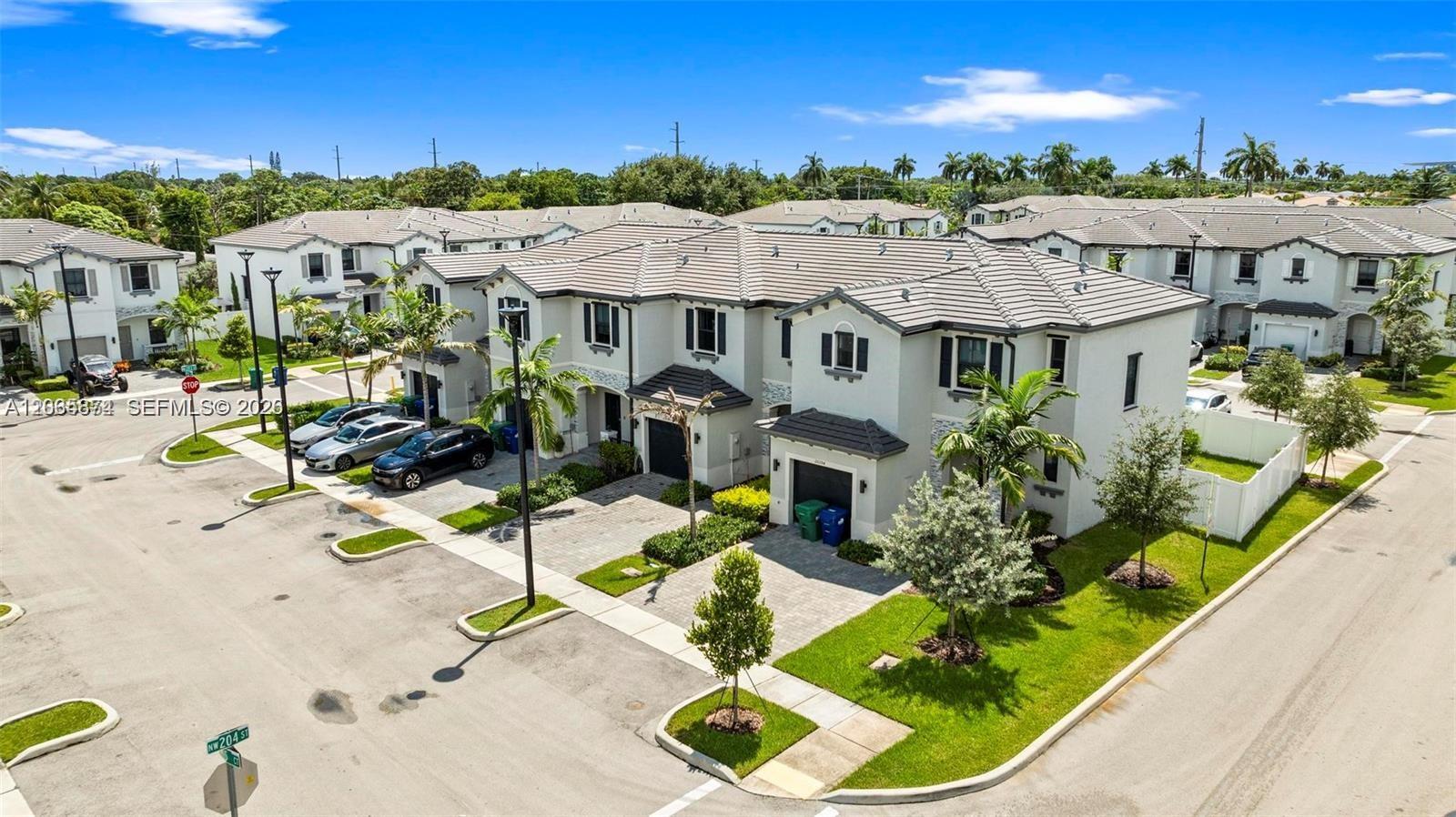 An aerial view shows a two-story residential townhouse complex with paved driveways and landscaping — 20380 NW 5th Ct, Miami Gardens FL 33169, MIAMI GARDENS, FL