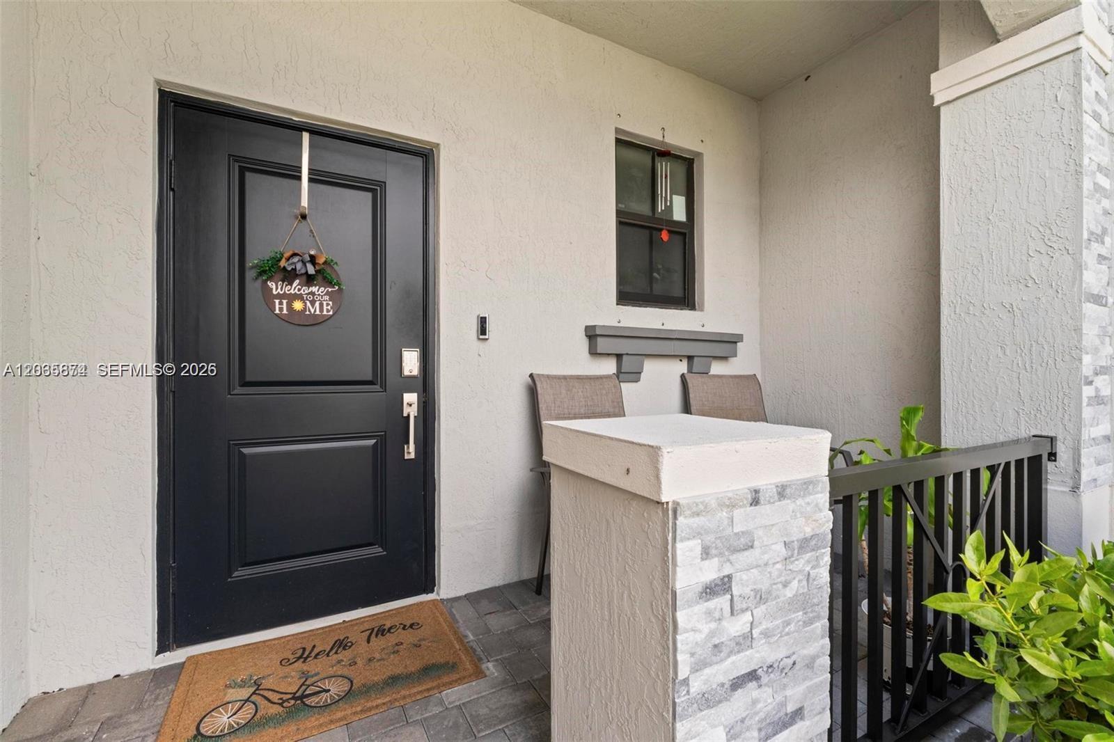 A front porch features a black door, a welcome sign, and a bicycle-themed doormat — 20380 NW 5th Ct, Miami Gardens FL 33169, MIAMI GARDENS, FL