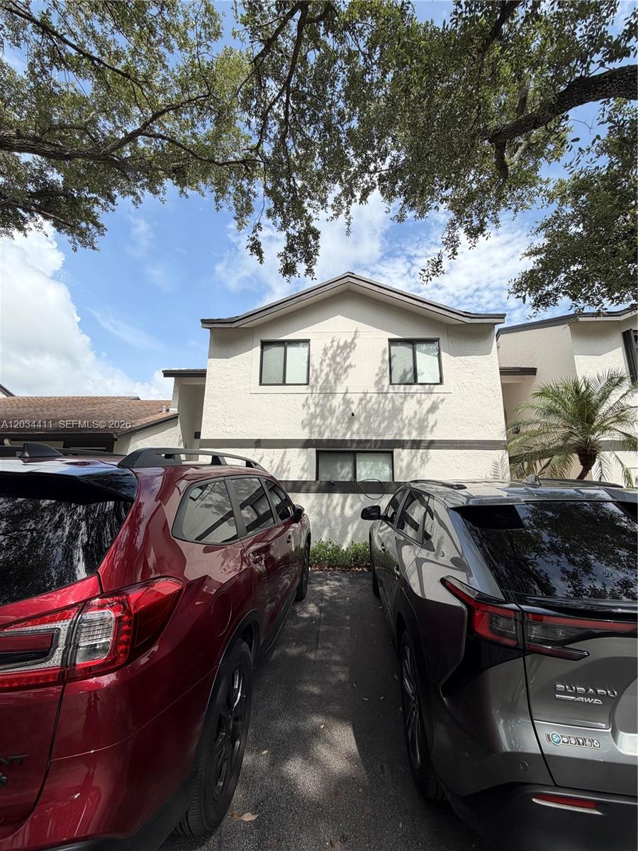 A two-story residential building exterior is viewed from a parking area with two parked cars — 9134 SW 118th Ct, Miami FL 33186, MIAMI, FL