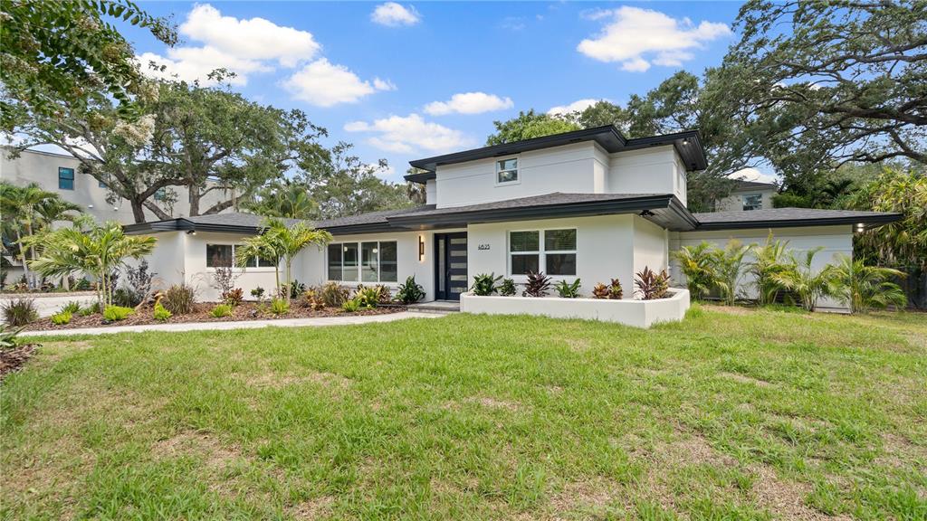 A modern two-story white house with a flat roof and dark trim sits on a lawn — 4623 W BROWNING AVENUE, TAMPA, FL