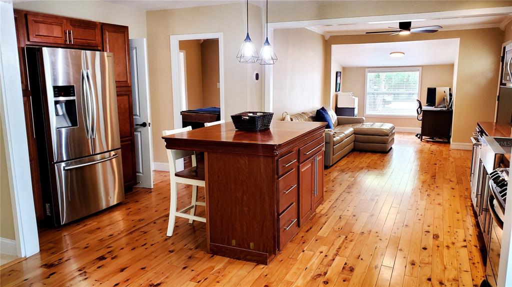 A kitchen with wood floors and a central island opens into a living area — 1722 ALBEMARLE ROAD, CLEARWATER, FL