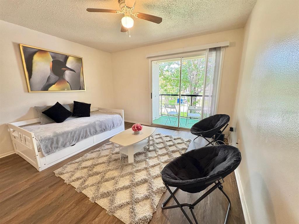 A living room features a daybed, two saucer chairs, a coffee table, and a balcony — 1916 LAKE ATRIUMS CIRCLE UNIT 44, ORLANDO, FL