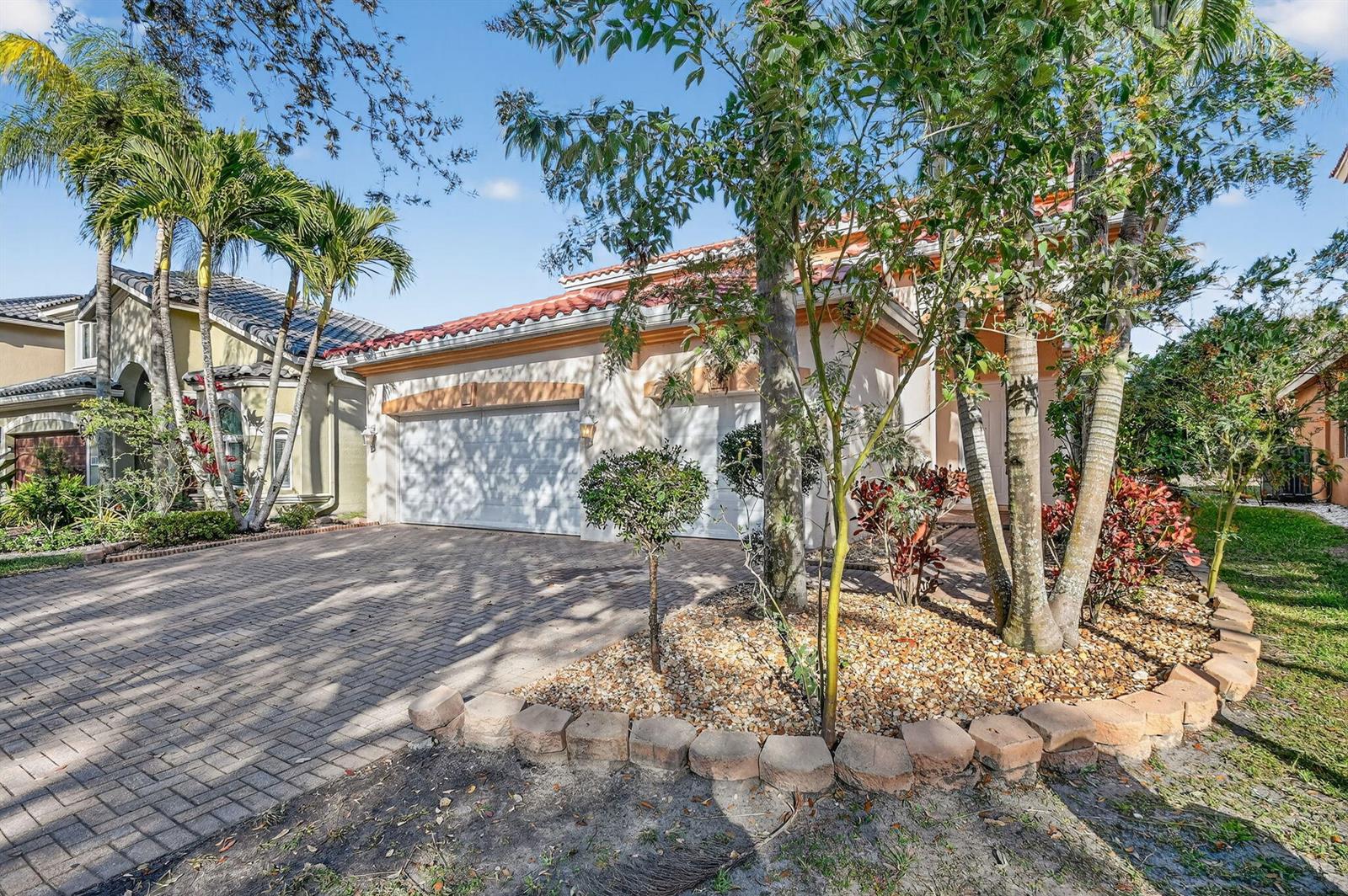 A beige house with a red tile roof, two-car garage, and a paved driveway — 876 Gazetta Way, West Palm Beach FL 33413, WEST PALM BEACH, FL