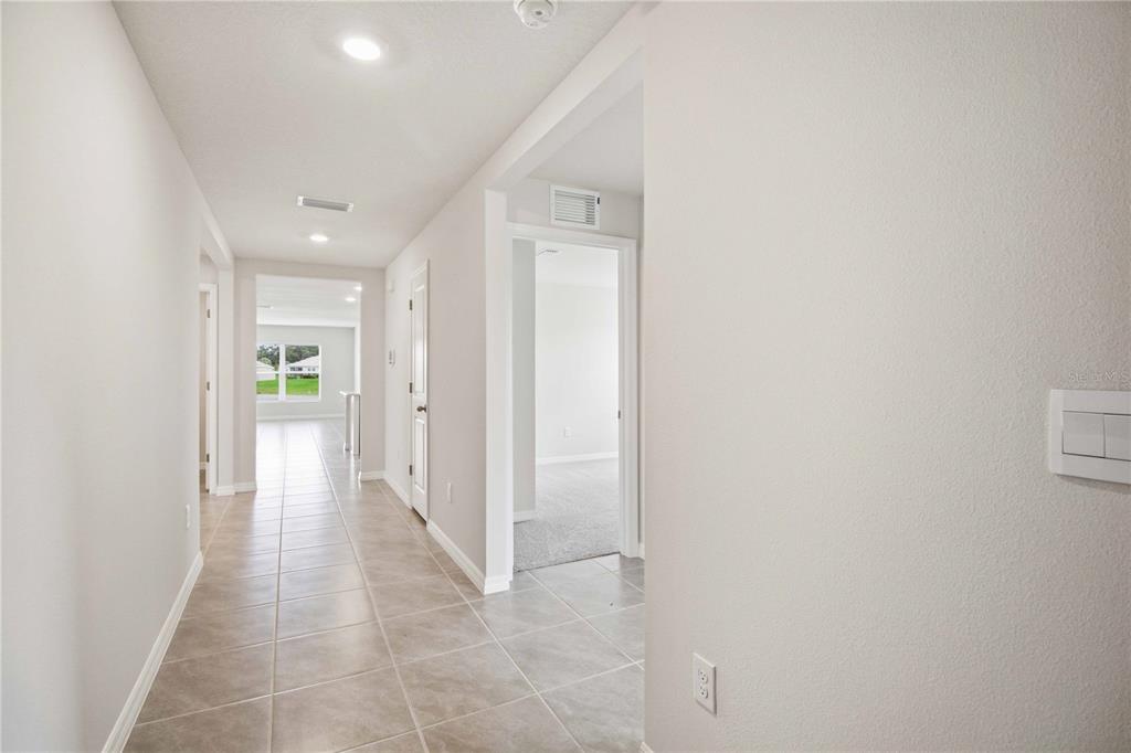 A tiled hallway leads to a doorway with a view of a carpeted room — 3906 111TH STREET E, PALMETTO, FL
