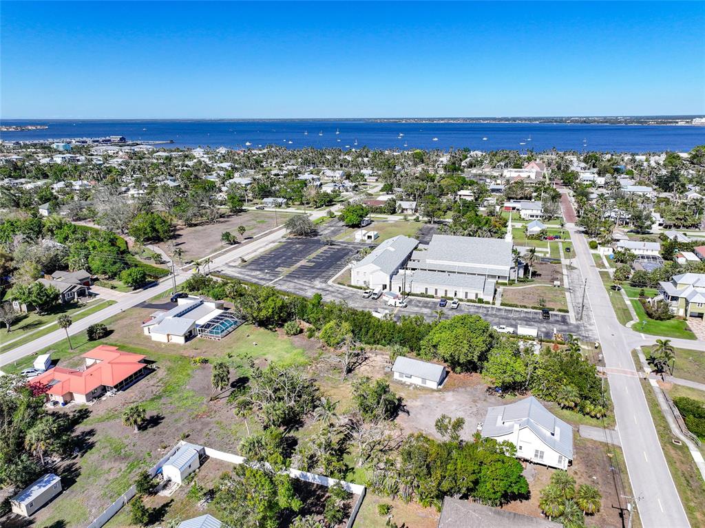 An aerial view shows a church with a large parking lot near a coastal waterfront — 479 & 509 GILL STREET, PUNTA GORDA, FL