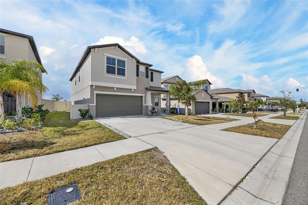 A bright hallway with tiled floors leads from a foyer toward an open dining area — 16791 DELIA STREET, WIMAUMA, FL