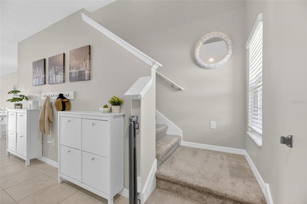 A kitchen with white cabinets, granite countertops, and a central island opens to a dining area — 16791 DELIA STREET, WIMAUMA, FL