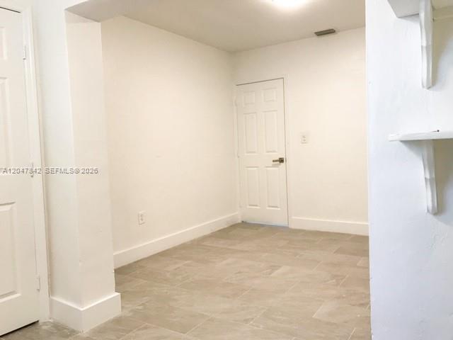 An interior room features white walls, a white door, and light-colored tile flooring — 2194 NW 18th Ter # 0, Miami FL 33125, MIAMI, FL