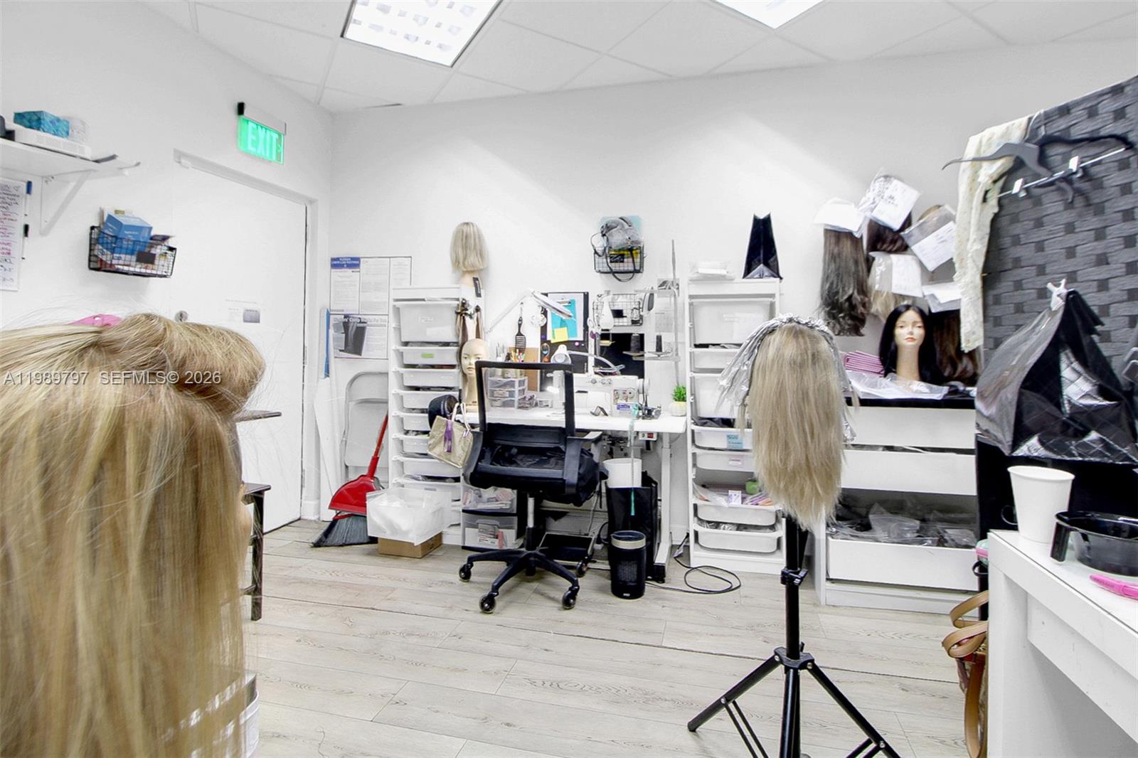 This hair salon workspace features multiple mannequin heads, a desk, and storage shelving — 3365 Sheridan St, Hollywood FL 33021, HOLLYWOOD, FL