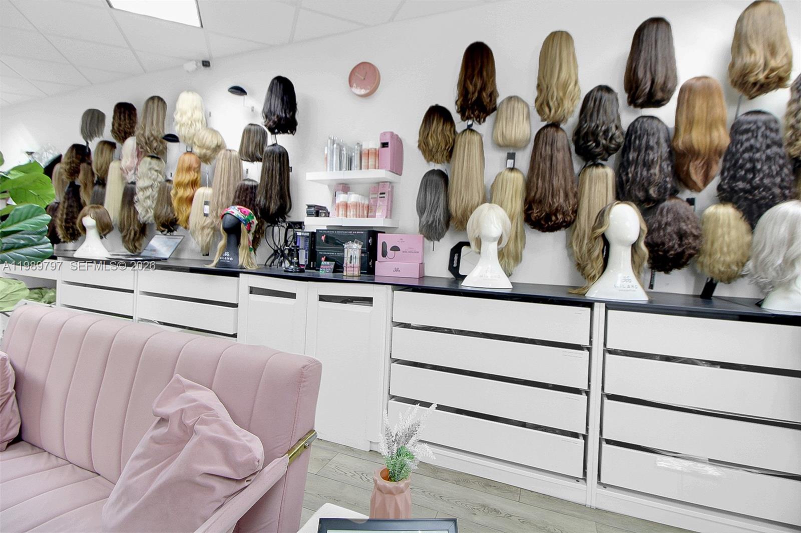 A retail wig shop features numerous mannequin heads displaying various hair styles on wall-mounted shelves — 3365 Sheridan St, Hollywood FL 33021, HOLLYWOOD, FL
