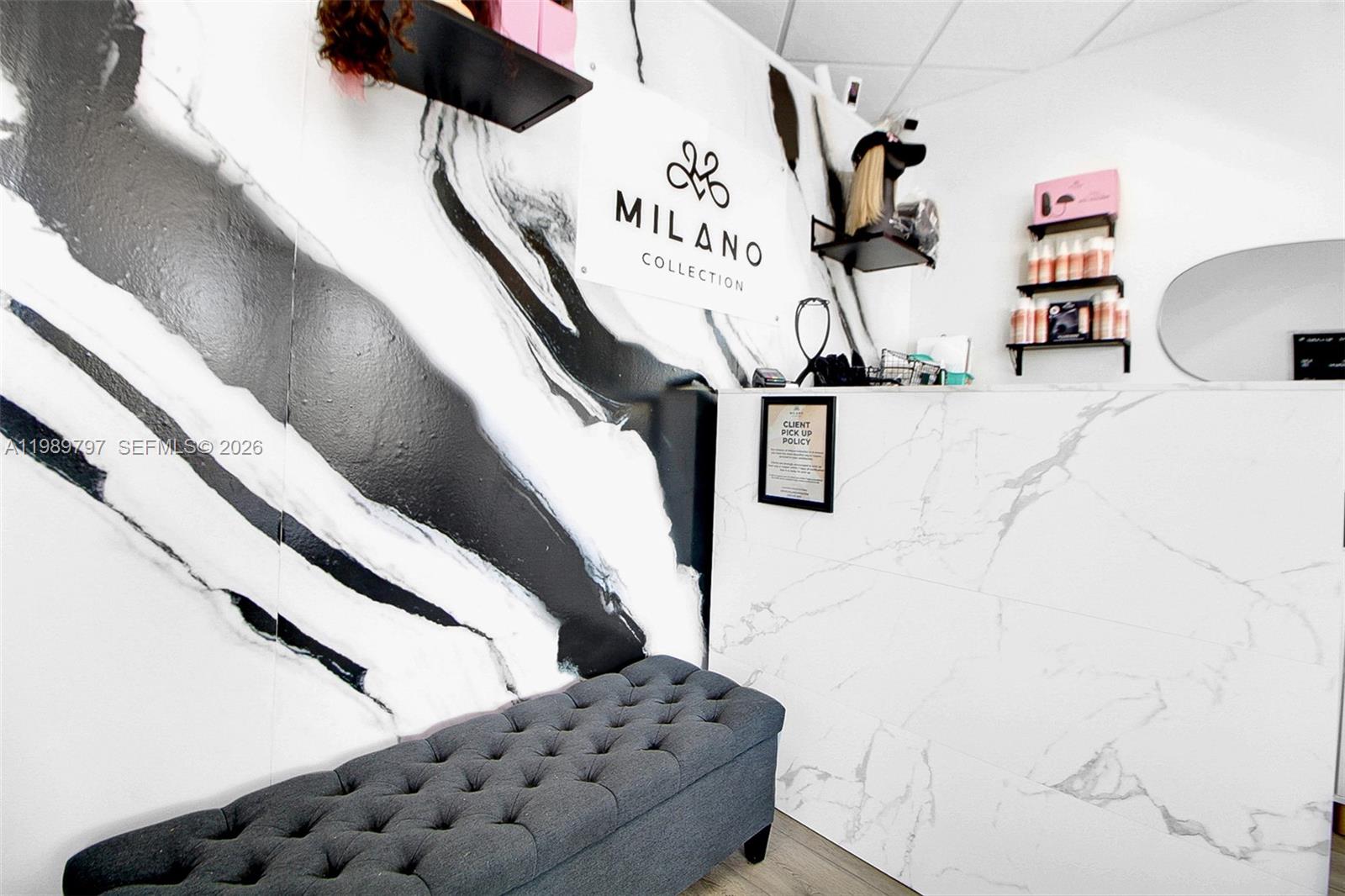 A reception area features a marble-patterned desk, a tufted grey bench, and branded wall signage — 3365 Sheridan St, Hollywood FL 33021, HOLLYWOOD, FL