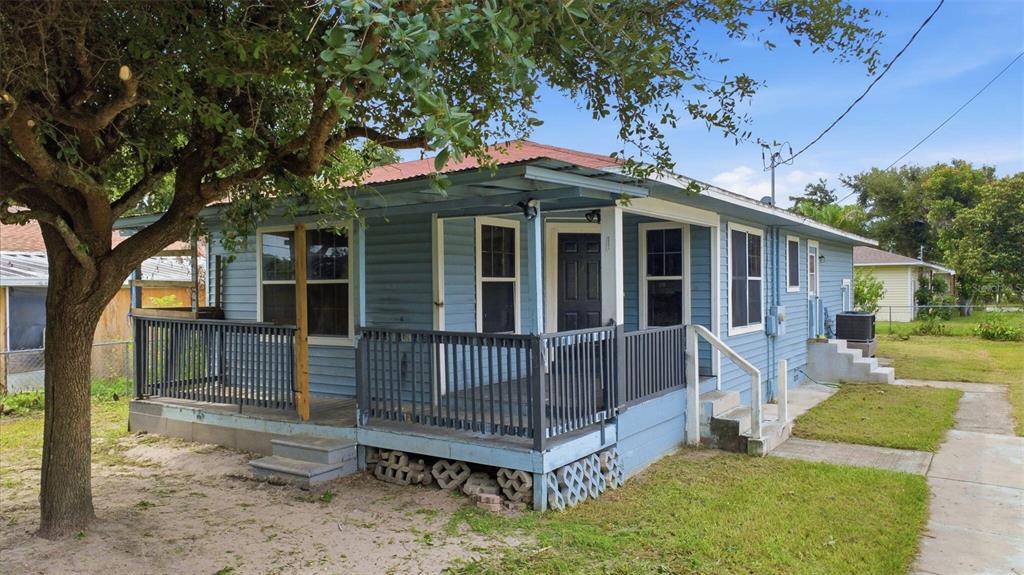 A light blue house with a covered front porch and a metal roof — 38407 LOWELL HARRIS WAY, DADE CITY, FL