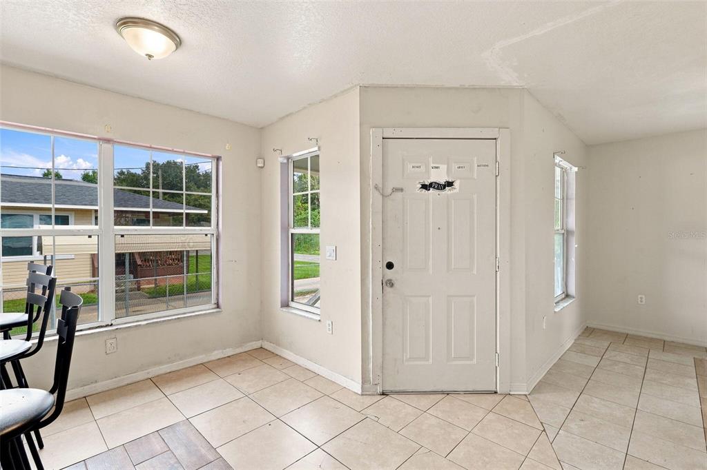 A bright room with tiled floors, a white front door, and several windows — 38407 LOWELL HARRIS WAY, DADE CITY, FL