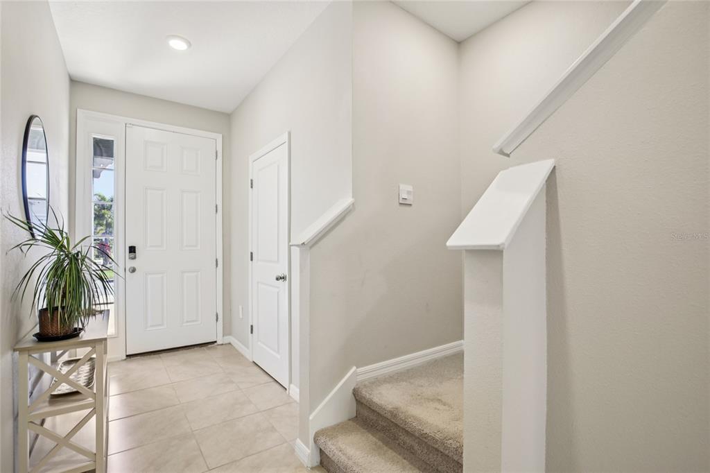 An entryway features a white front door, a tiled floor, and carpeted stairs — 2813 MIDNIGHT PEARL DRIVE, SARASOTA, FL