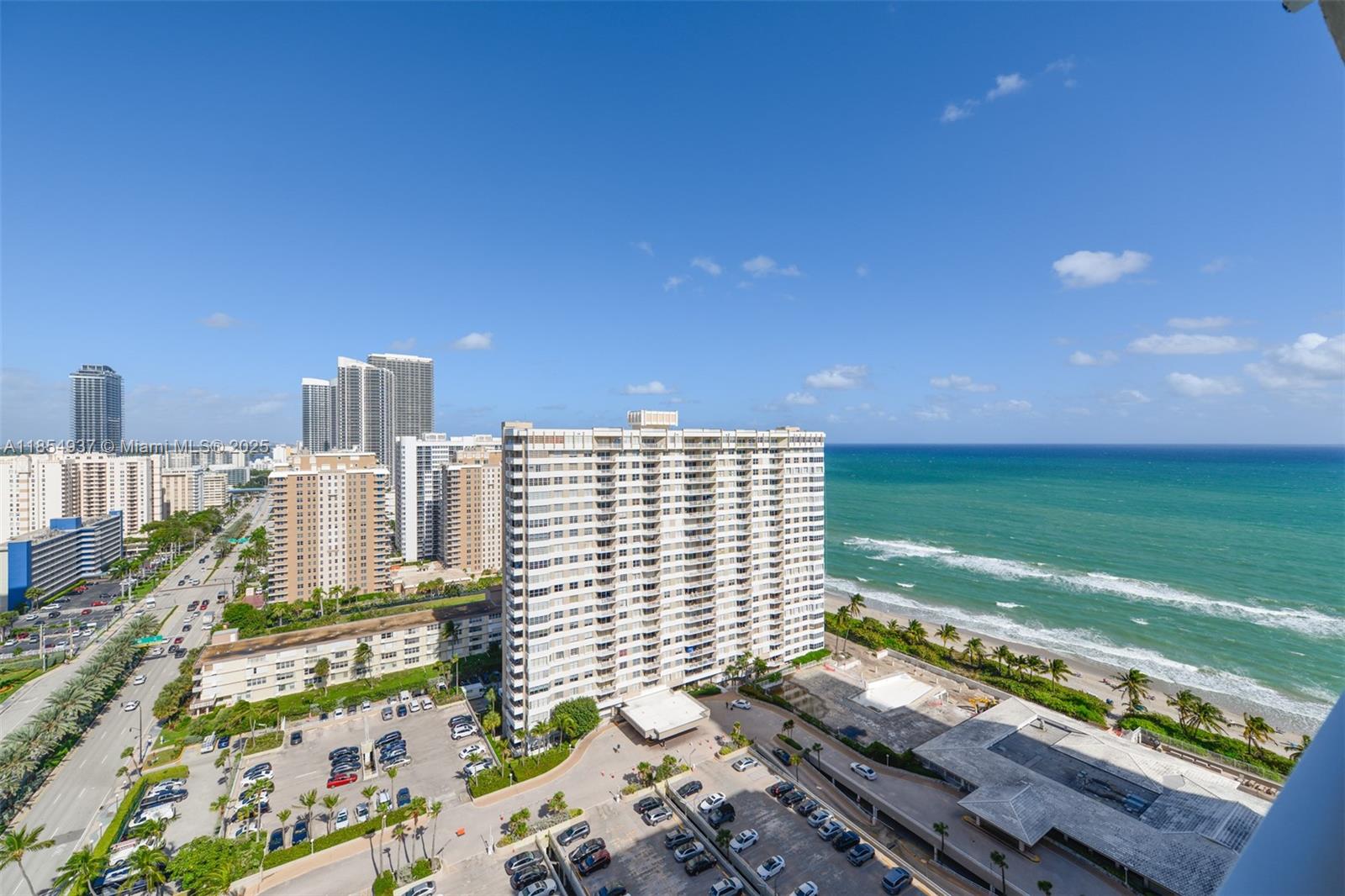 An elevated exterior view shows a coastal city skyline, high-rise buildings, and the ocean — 1980 S Ocean Dr, Hallandale Beach FL 33009, HALLANDALE BEACH, FL