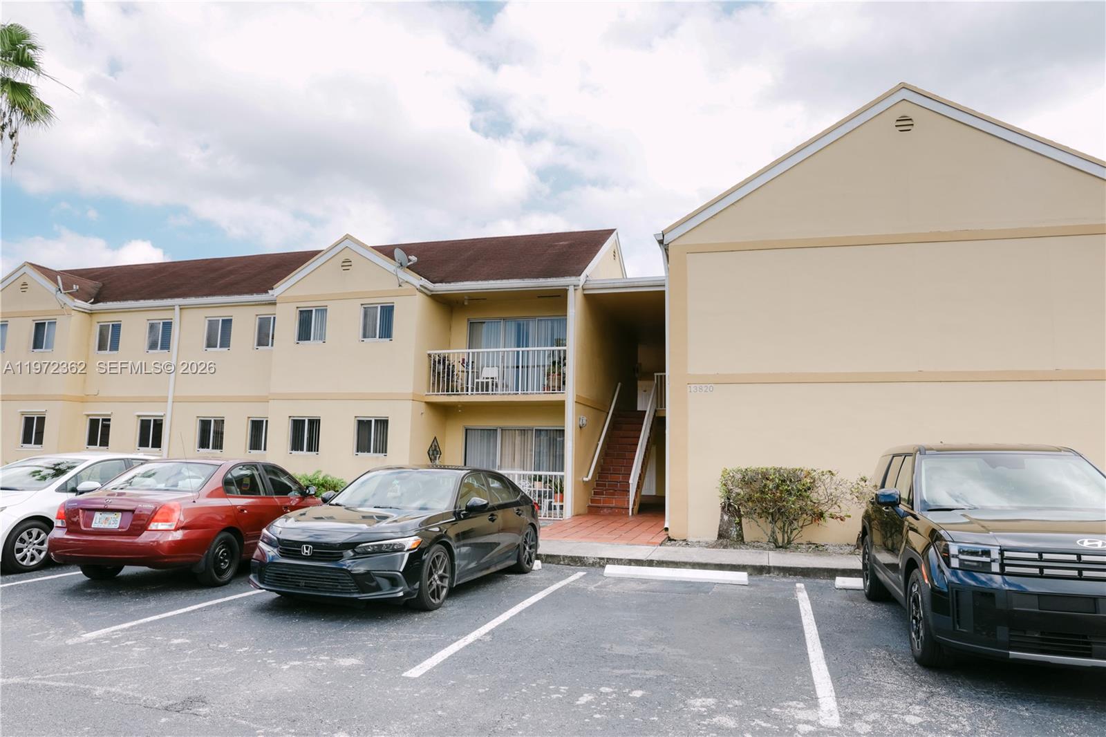 A two-story apartment building with a parking lot in the foreground — 13820 SW 112th St # 204, Miami FL 33186, MIAMI, FL