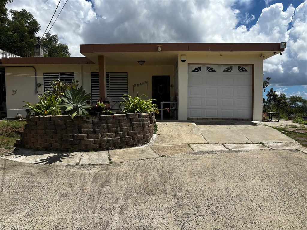 A single-story house with a garage, a stone planter, and a concrete driveway — Km 1.9 842 CARRETERA, SAN JUAN, PR