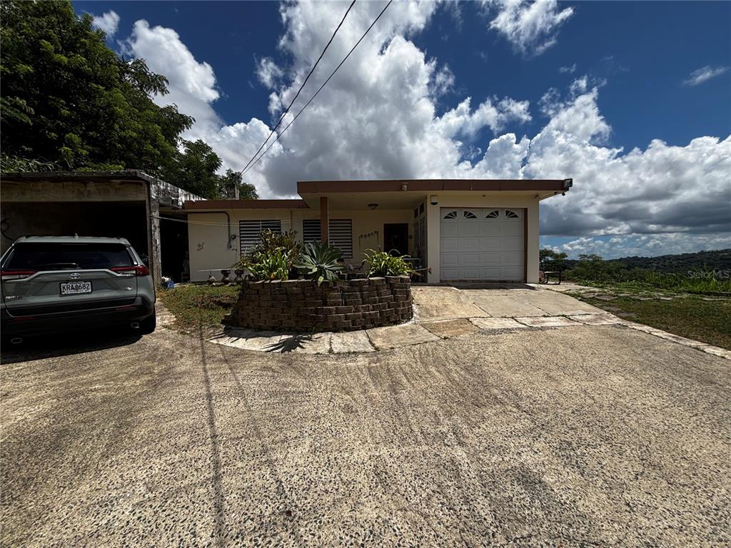 A single-story house with a garage, a stone planter, and a concrete driveway — Km 1.9 842 CARRETERA, SAN JUAN, PR