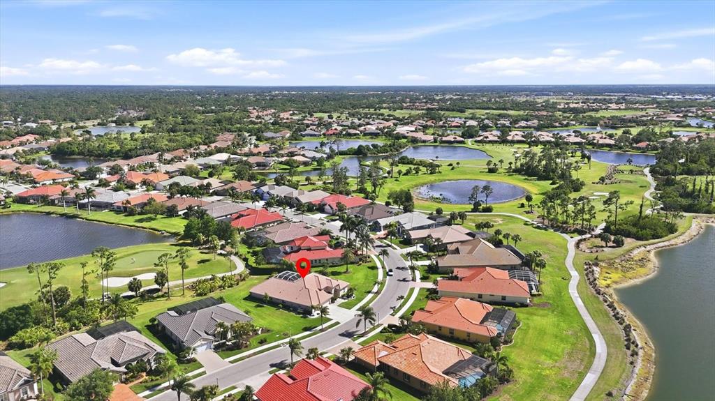 An aerial view shows a residential neighborhood with houses, lakes, and a golf course — 1166 EAGLES FLIGHT WAY, NORTH PORT, FL