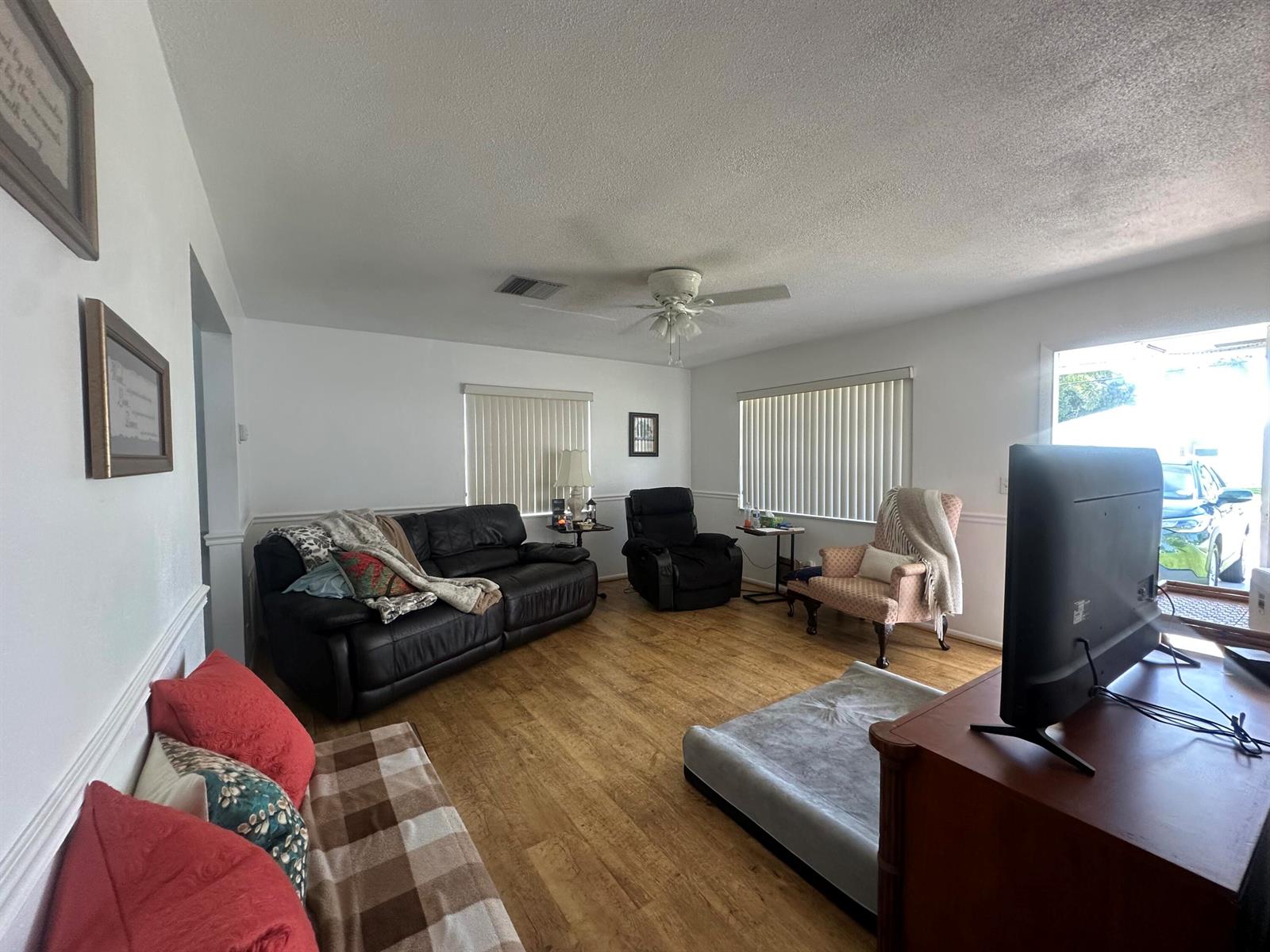 A living room features a black leather sofa, a recliner, an armchair, and wood flooring — 806 Ocean Drive, Boynton Beach FL 33426, BOYNTON BEACH, FL