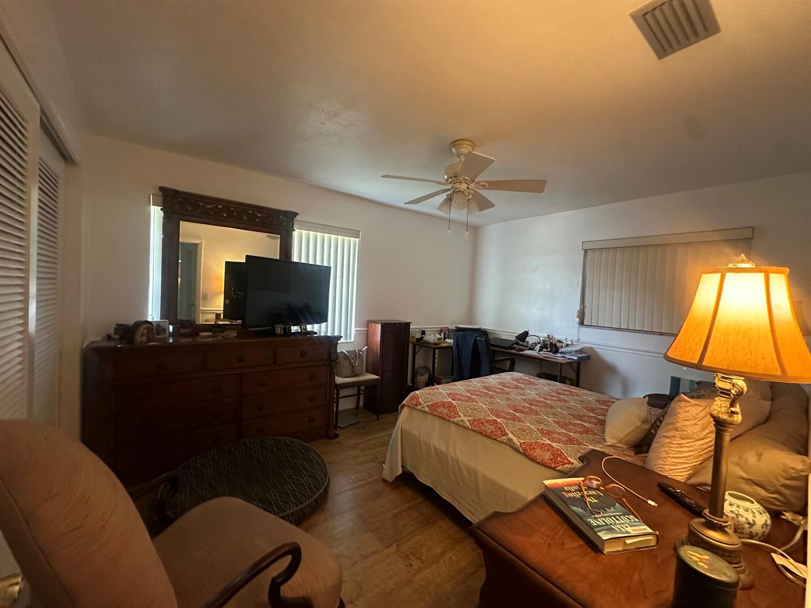 A bedroom features a bed, a wooden dresser with a mirror, and a ceiling fan — 806 Ocean Drive, Boynton Beach FL 33426, BOYNTON BEACH, FL