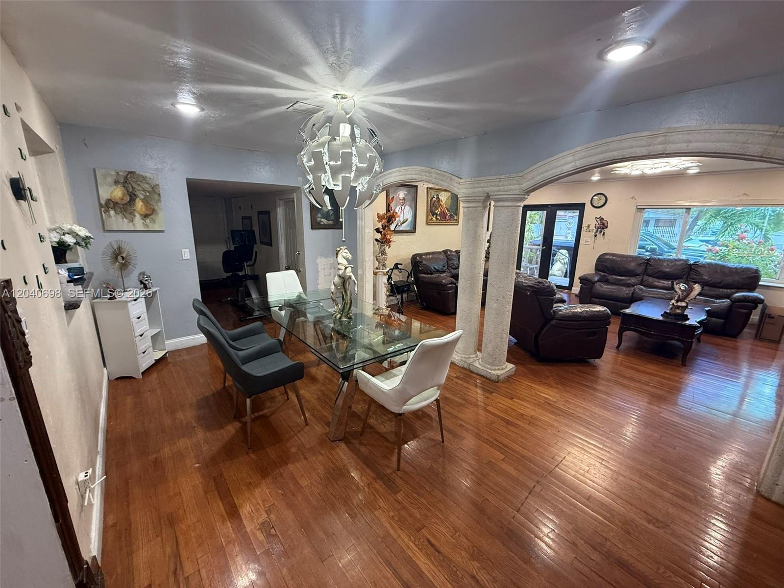 A dining area with a glass table and chairs sits before a living room with columns — 202 To To Lo Chee Dr, Hialeah FL 33010, HIALEAH, FL