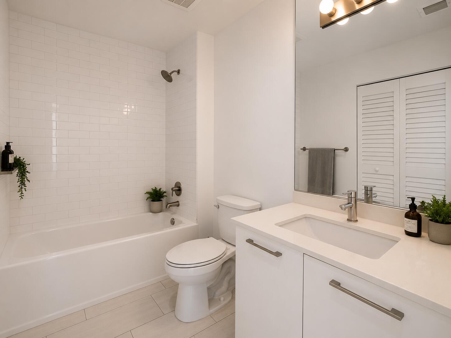 A modern bathroom features a white subway-tiled shower, a vanity with a sink, and toilet — 151 SE 1st Street # 608, Miami FL 33131, MIAMI, FL